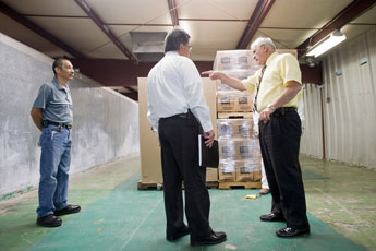 School superintendent Ray Arsenault, right, and Public Education Department Finance and Operations Deputy Secretary Hipolito Aguilar, center, talk with warehouse supervisor Martin Padilla at the Gallup McKinley County Schools R&D Warehouse Wednesday. © 2011 Gallup Independent / Cable Hoover 